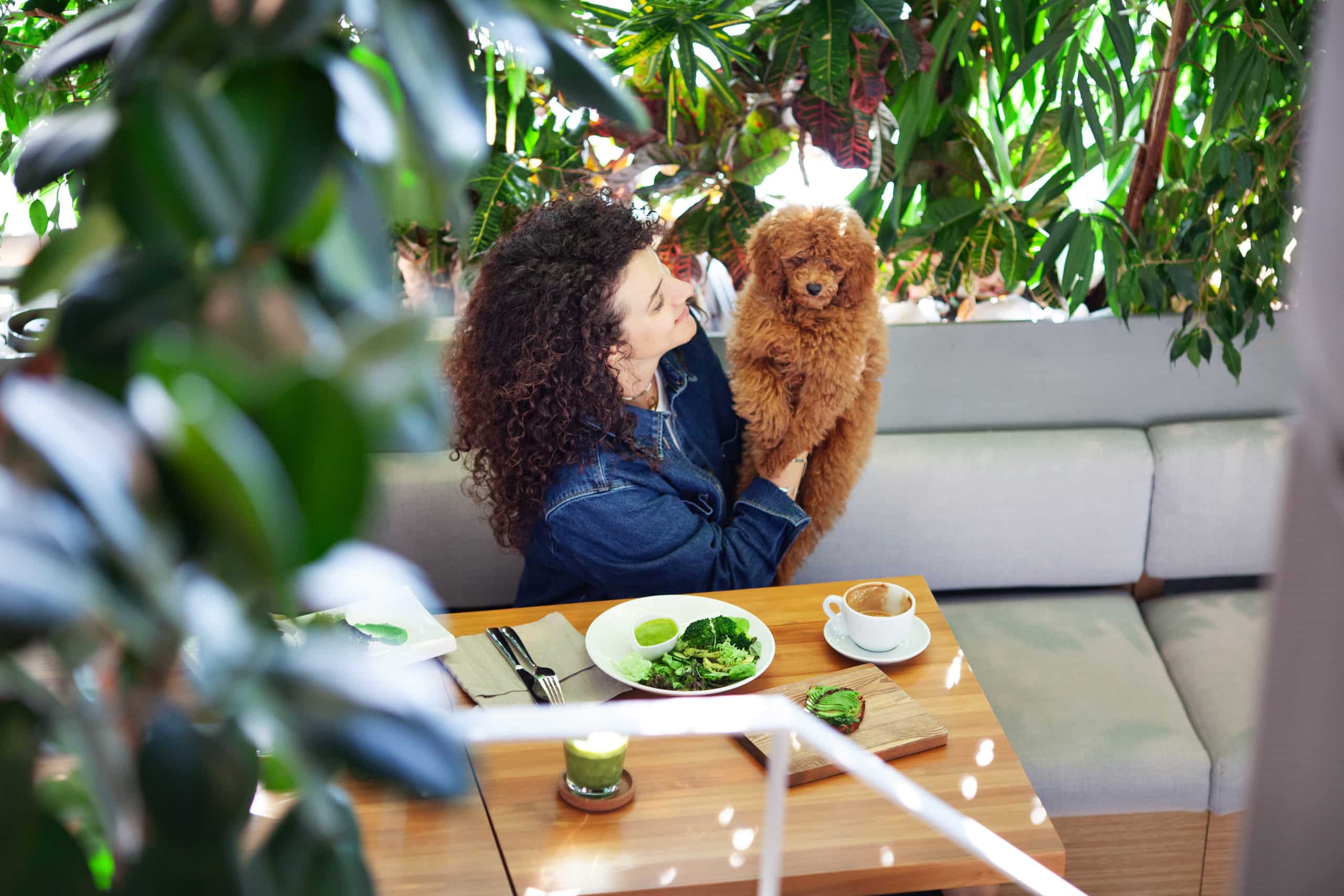 Owner with her dog at an outdoor garden café table