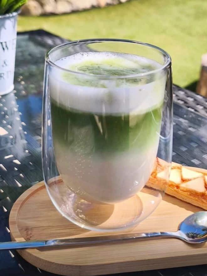 Iced matcha latte in a glass tumbler with pastry
