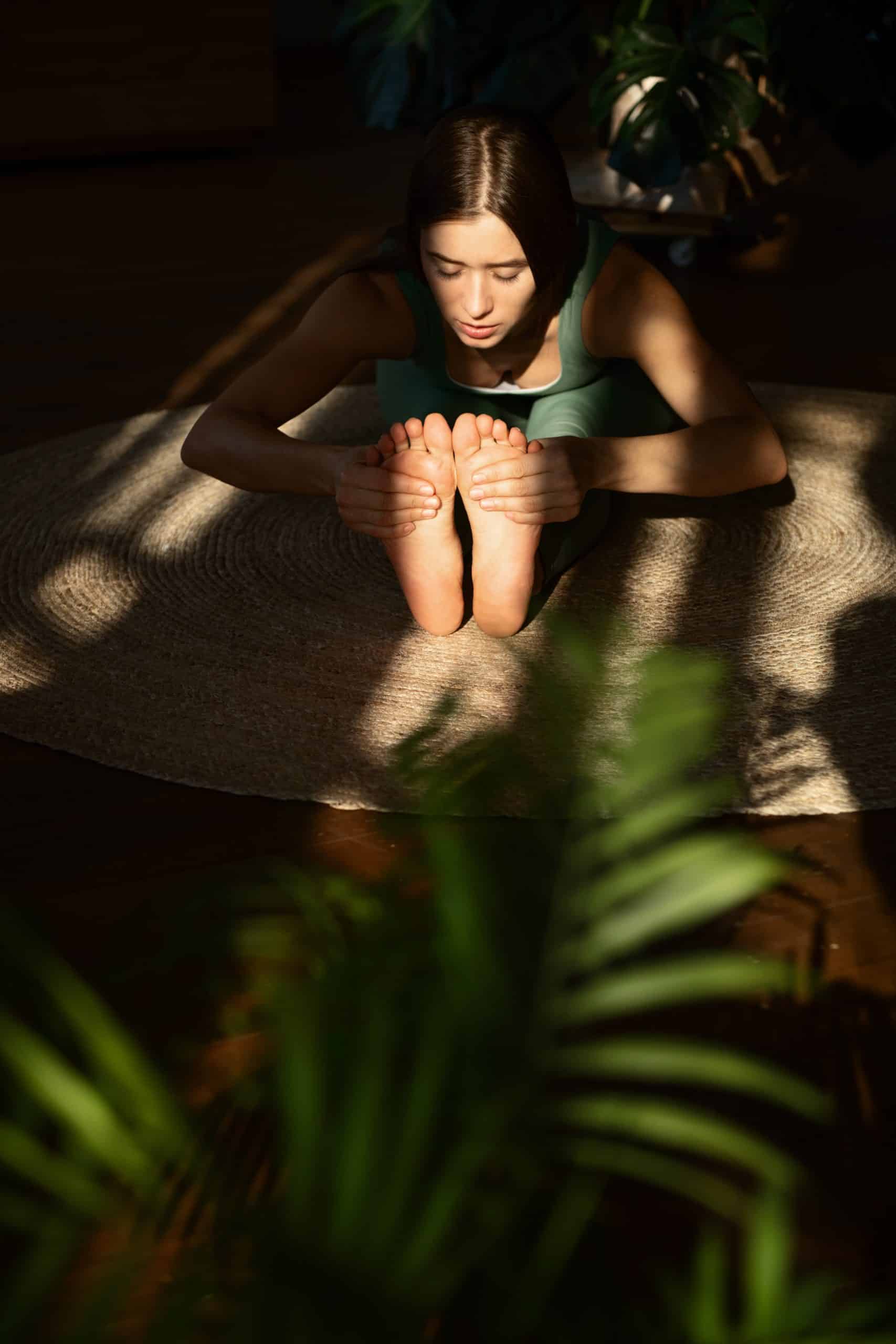 Woman in a seated forward-fold yoga pose at Luz Aura Yoga & Wellness Studio Vilamoura